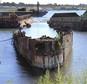FILE - In this Aug. 22, 2016 file photo, rusting remnants of an old Russian submarine, used as a set for a Harrison Ford movie and as a floating museum until sinking during a 2007 nor'easter, sits rusting in a scrapyard in the Providence River in Providence, R.I. State environmental officials sued to have the sub and several other vessels removed from the river. A state superior court judge ordered Rhode Island Recycled Metals LLC in December to begin removing the vessels from the river. The permitting process is underway. (AP Photo/Jennifer McDermott, File)