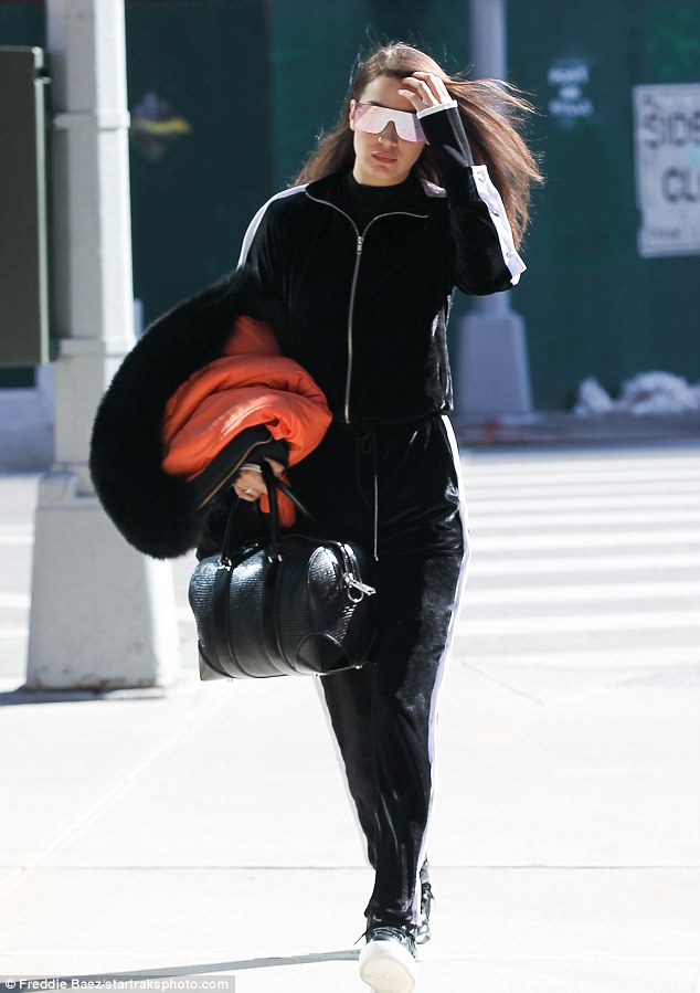 The 20-year-old model was spotted wearing a black velour tracksuit with white stripe design and oversize mirrored shades