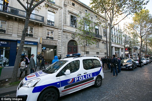 The crime scene: A French police car is seen outside Kim's apartment after she was robbed at gunpoint by masked men