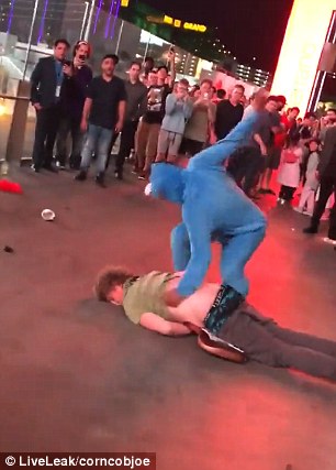 Caught on camera: The man in the Eeyore outfit proceeds to strike the man on the ground