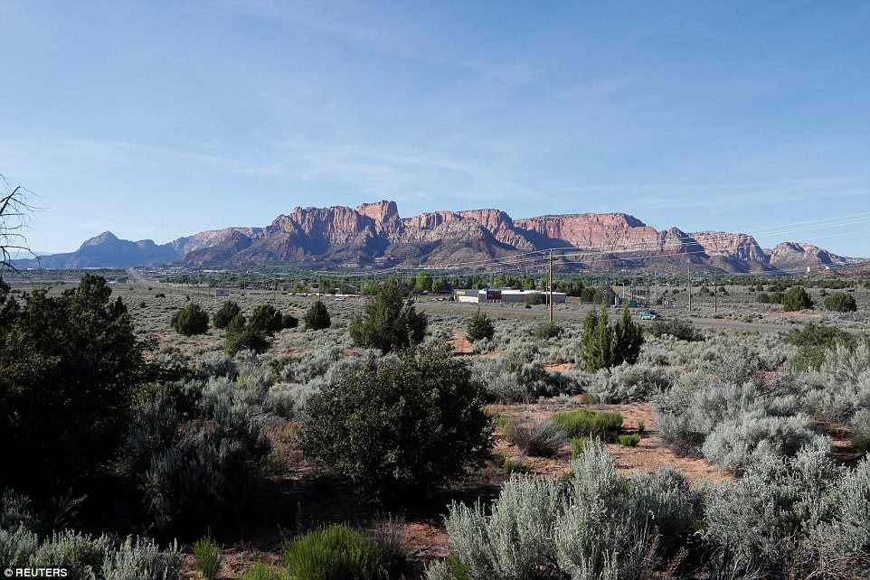 Red rock cliffs rise above Colorado City, Arizona and Hildale, Utah, near Jeffs' former compound 