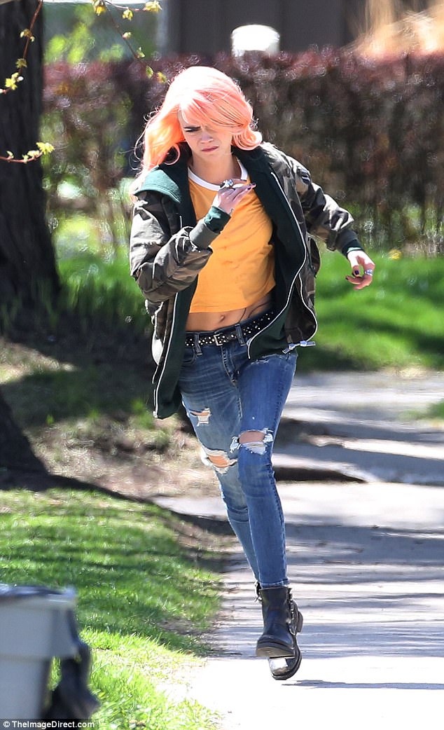Think pink: Cara Delevingne was pictured running on the set of her new film, Life In A Year, on Thursday, once again rocking a pink hairpiece as she got into character on the Toronto set