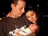 Monica Thompson is suing the hospital where her son Jacob suffocated under her in 2012 for leaving her alone with him while she was drowsy. She is pictured with the baby and her husband Graham before they turned off  his life support