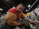 Egyptian Body builder: Moustafa Ismail lifts free weights during his daily workout at World Gym in Milford, Massachussettes - his biceps measure 31 inches