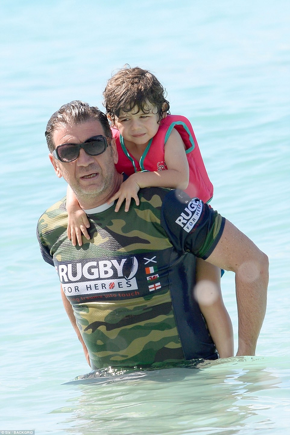 Doting dad: Nick frolicked in the sea with the former couple's son Eddie, three
