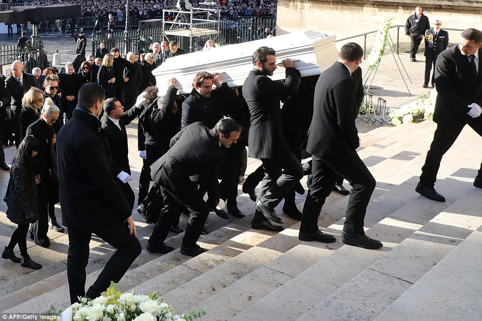 Relatives of the late French rock star carry his white coffin into the Madeleine Church in Paris for his funeral 