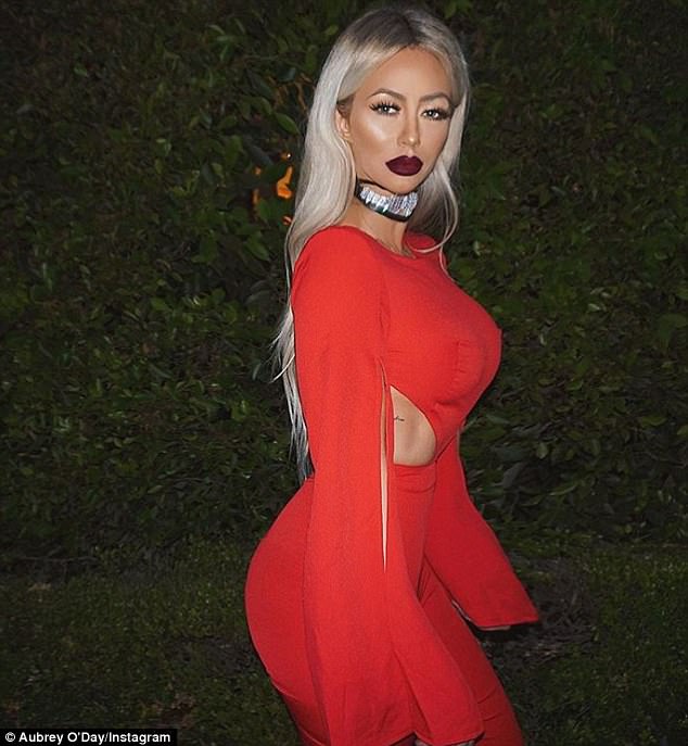 'Swimin in milk n honey': The Celebrity Big Brother 18 contestant struck a sultry pose in a red cut-out Hot Miami Styles jumpsuit and Unékform choker