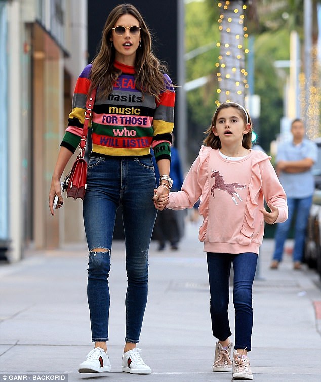 Bold move: At one point during her shopping trip, Alessandra stood out in a bright, striped Etro sweater, that appeared to read; 'The earth has its music for those who will listen