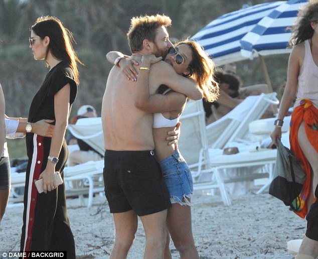 Cosy: David showed off his impressively toned physique in black swimming trunks as he joined his stunning girlfriend on the beach