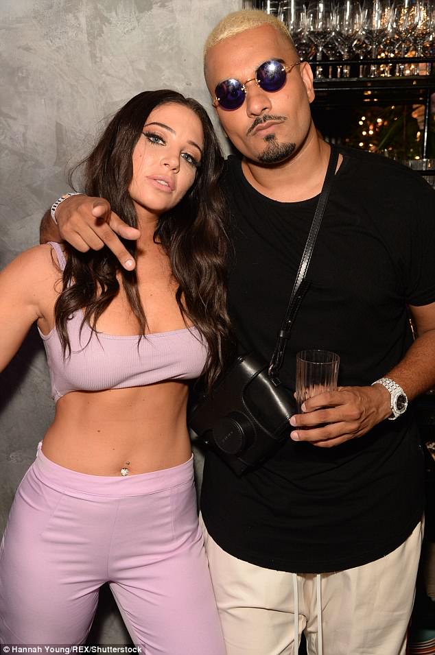 Strike a pose: Tulisa, 29, dressed to impress for the celeb-packed party in her tiny crop top as she posed up a storm with the clothing giant's billionaire founder Umar Kamani