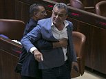 A Knesset usher removes Jamal Zahalka, an Israeli Arab member of the Knesset representing the Balad party, who was protesting the passage of a contentious bill 