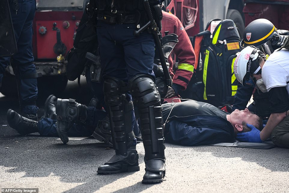 A member of the French anti-riot police CRS receives medication after being injured during clashes with demonstrators