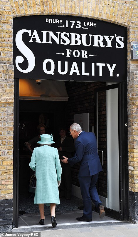 The Queen walks through the doors of the pop-up shop, designed in a 1860s style