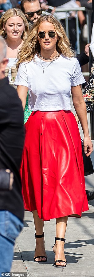 The 'Dark Phoenix' actress dressed up a basic white Re/done t-shirt by pairing it with a red leather skirt by MSGM and ankle-strap stilettos
