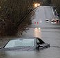 A driver drove past road closed signs on Southeast Seventh Place in Bellevue, Wash., near the Lake Hills Connector, which was covered with about four feet of water, and was able to swim to safety when the car stalled, Friday, Dec. 20, 2019. A storm that has brought record rainfall to the Northwest has broken some records, prompted flood warnings, disrupted train traffic and caused some power outages. (Ellen M. Banner/The Seattle Times via AP)