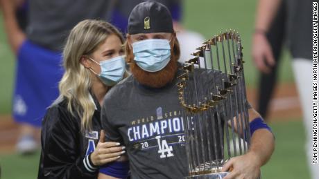 ARLINGTON, TEXAS - OCTOBER 27:  Justin Turner #10 of the Los Angeles Dodgers and his wife Kourtney Pogue, hold the Commissioners Trophy after the teams 3-1 victory against the Tampa Bay Rays in Game Six to win the 2020 MLB World Series at Globe Life Field on October 27, 2020 in Arlington, Texas. (Photo by Tom Pennington/Getty Images)