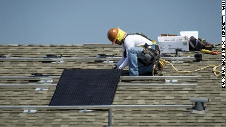 A contractor installs a SunRun Inc. solar panel on the roof of a new home at the Westline Homes Willowood Cottages community in Sacramento, California, U.S., on Wednesday, Aug. 15, 2018. California is the first state in the U.S. to require solar panels on almost all new homes as part of a mandate to take effect in 2020. Photographer: David Paul Morris/Bloomberg via Getty Images