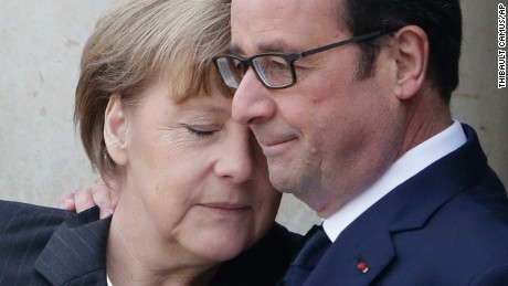 French President Francois Hollande embraces German Chancellor Angela Merkel as she arrives at Elysee Palace before the rally.