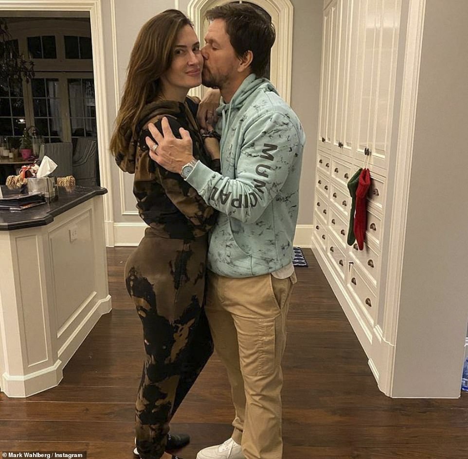 Loved up: Mark Wahlberg meanwhile shared a snap of himself kissing wife Rhea Dunham as he shared she was his 'best gift ever'