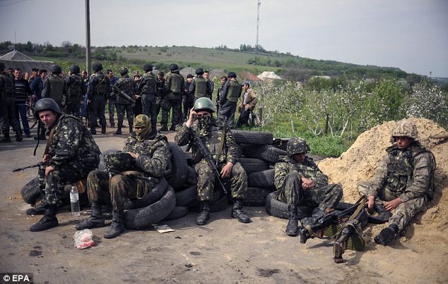 Battle fatigue: Ukrainian soldiers rest near of a checkpoint seized not far from Slaviansk. The Ukrainian Security Service said its forces were fighting 'highly skilled foreign military men' in the city