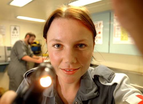 Seaman Medic Jodie Schumacher checks the ear with an Otto scope, in the sick bay of HMAS Perth.