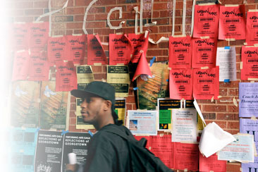 A student walks by a bulletin board of fliers at Georgetown University