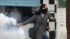 Man tries to throw tear gas canister back at police, Tunis, 18 Jan 2011