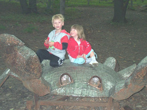 kids playing on spider in woods at Griffis Sculpture Park