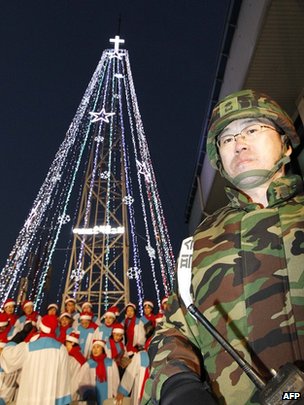 South Korean military officer stands guard as Christians prepare a lighting ceremony of a tree near the border with the North in December 2010