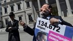 Activists in Madrid stage a satirical performance depicting Prime Minister Mariano Rajoy (R) and bailed-out bankers (L) 