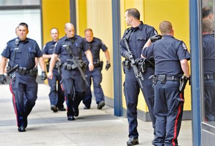 Police cover the north emergency exit doors at City Centre Mall east while responding to what turned out to be a false sighting of armoured guard Travis Baumgartner, accused mass killer in the shooting of four G4S armoured guards Friday in Edmonton, June 16, 2012.