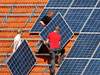 Photo: Workers install solar panels on a barn in Binsham, Germany.
