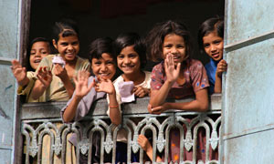 Group of Indian children waving at camera from balcony, Jaipur, Rajasthan, India
