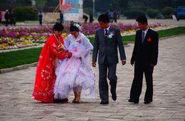 Newlyweds stroll the boardwalk near Wonson beach. Couples meet in around town, at work or military units, in college, or through friends and family. North Korean go through a courting process, propose, get engaged, have a wedding, and go on honeymoons and start families. Copyright © Michael Bassett. All Rights Reserved