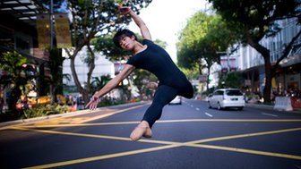 Ballet dancer leaping in Singapore street scene 