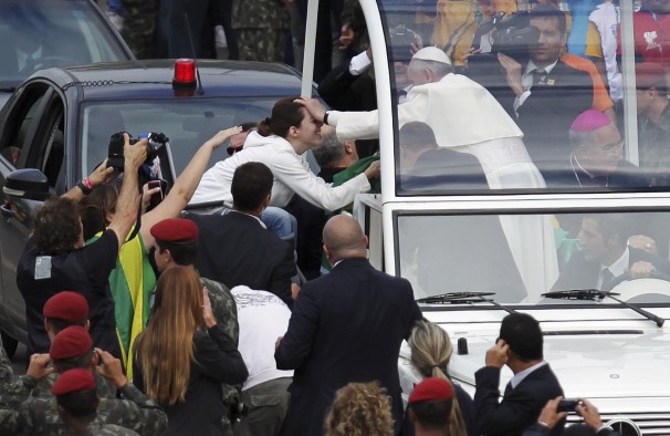 Pope Francis blesses a woman as he arrives for his final Mass on Copacabana Beach in Rio de Janeiro.