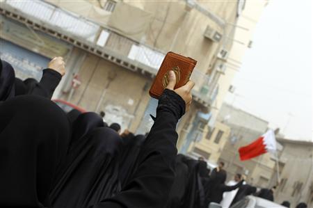 A female anti-government protester holds up a Koran during a march to demand the end of the regime on the streets of Sanabis in Manama June 3, 2011. REUTERS/Hamad I Mohammed