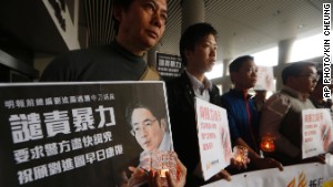 Protesters hold a picture of former Ming Pao editor Kevin Lau outside a hospital in Hong Kong.