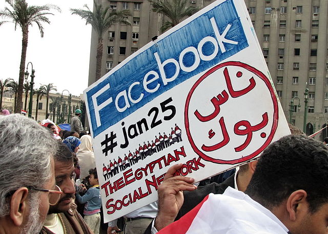 Protestors hold up a Facebook placard in Tahrir Square