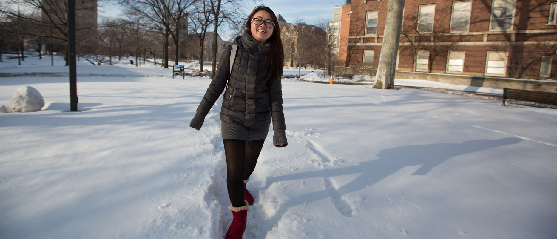 photo of a CWRU female student walking through snow