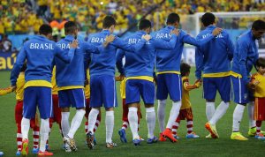 Brazilian football team walks onto the pitch with hands on shoulders
