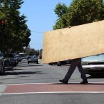 Workers carry plywood across International Blvd. in preparation for possible protests after the Mehserle verdict. (CALIFORNIA BEAT PHOTO)