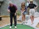 Then-president Bill Clinton lines up a shot as his daughter, Chelsea, and wife, Hillary. watch while playing miniature golf at the Island Cove Mini Golf course in Vineyard Haven, Mass., on Aug. 28, 1993.