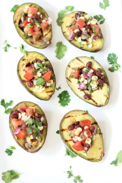 Grilled avocados are stuffed with a light and fresh mixture of corn, black beans, and tomatoes in this elegant yet simple appetizer, side dish, or vegetarian entrée. @jlevinsonrd