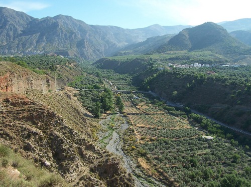 Acequias (Lecrín) sobre el río Torrente, Valle de Lecrín, Granada. Al fondo: los Cahorros de Nigüelas en la ladera baja de sierra Nevada.