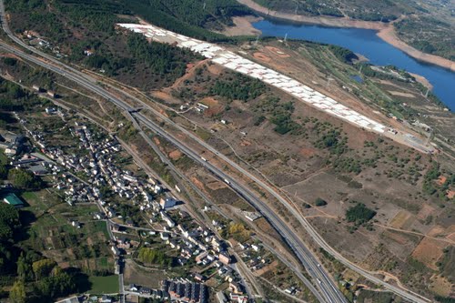 Vista aérea de San Miguel de las Dueñas, autovía A-6, un almacén de palas de aerogeneradores, y el embalse de Bárcena
