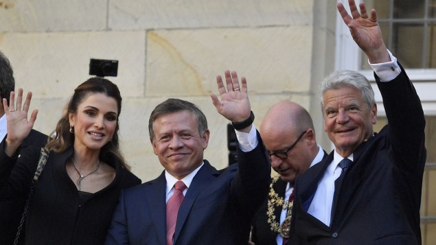 Queen Rania, left, and King Abdullah of Jordan, center, with German President Joachim Gauck wave to citizens on the historic town hall balcony in Muenster, Germany, Saturday, Oct. 8, 2016. (AP Photo/Martin Meissner)