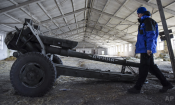 In this March 2015 photo, an OSCE monitor inspects a cannon stored by Russia-backed separatists in eastern Ukraine. (AP Photo/Mstyslav Chernov)