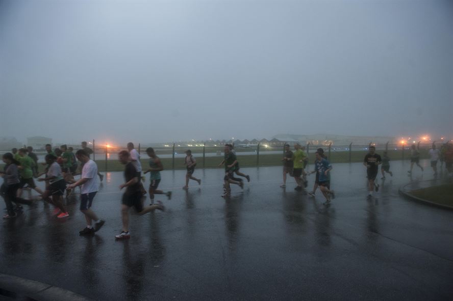 Participants of the Green Dot Color Me Green Fun Run jog near the flightline Nov. 21, 2016, at Kadena Air Base, Japan. Green Dot is a power-based interpersonal violence prevention program geared toward preventing and reducing violence affecting Airmen. (U.S. Air Force photo by Senior Airman Lynette M. Rolen/Released)