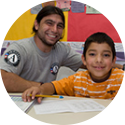 AmeriCorps member posing with a young boy in school. 